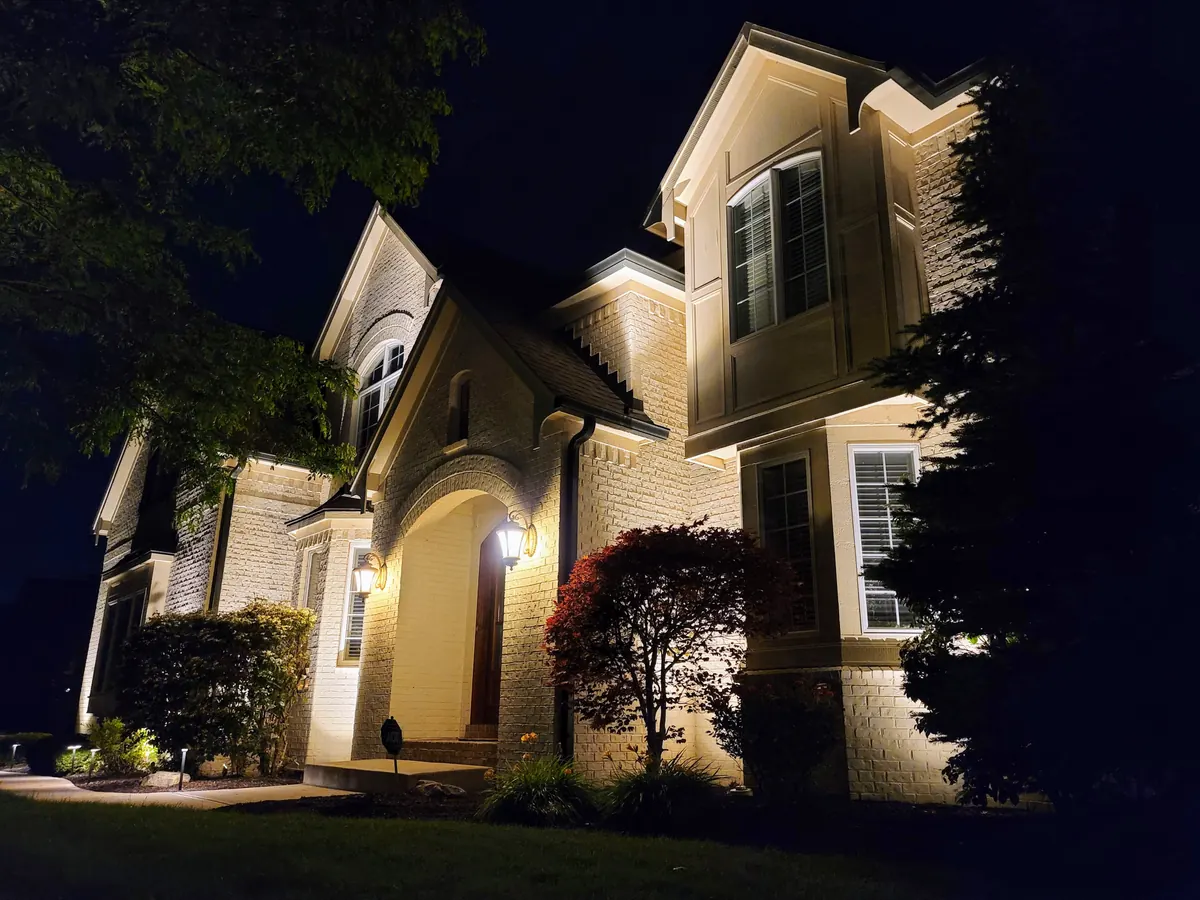 Landscape and patio uplighting on a stone-front Indianapolis residence